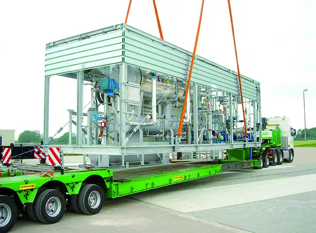 Mobile Industrieanlage wird auf einen Tieflader gehoben.